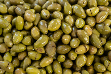 Close-up texture of delicious green olives, cracked and seasoned, forming a vibrant pattern, highlighting turkish culinary tradition, healthy food, and mediterranean appetizers