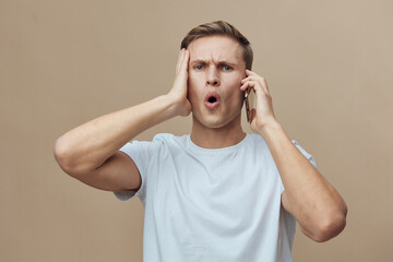 shocked young caucasian man hold smartphone use cybersecurity concept worry expression casual white...