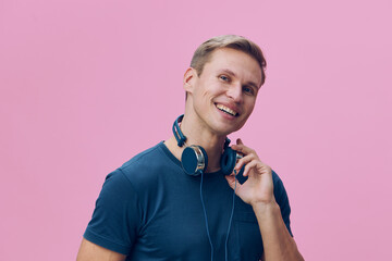 smiling young man with headphones hold mobile phone digital nomad remote work cyber security...