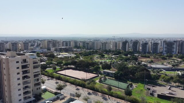Aerial drone view of Afula, a city in northern Israel, showing urban neighborhoods, residential buildings, roads, and surrounding landscape. Modern Israeli cityscape captured from above, highlighting 