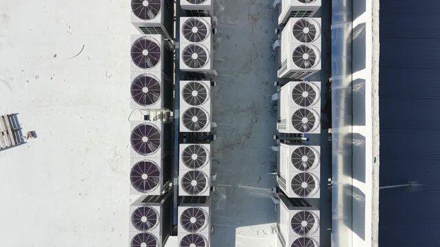 Industrial air conditioning ventilation system with large cooling fans and motors. HVAC infrastructure equipment installed on rooftop of commercial building. Climate control and industrial engineering