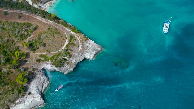 Cinematic Aerial Drone View of Makris Gialos beach in Zakynthos Greece with turquoise water rocky coves boats