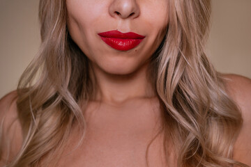Close-up portrait of young blonde woman with red lipstick and soft wavy hair. Natural beauty...