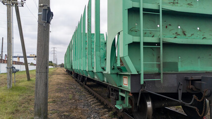 Empty timber cars close up. Railroad cars loaded with timber on the tracks. Timber trade. Freight transport.