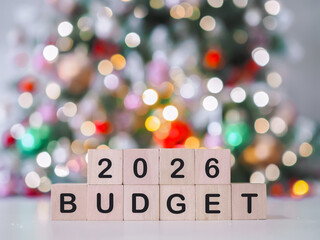 Wooden blocks with the word BUDGET and number 2026 with shiny light for Christmas background. The concept about budget planning and allocation in year 2026