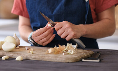Woman Cleaning Garlic In The Kitchen At Home Close-Up