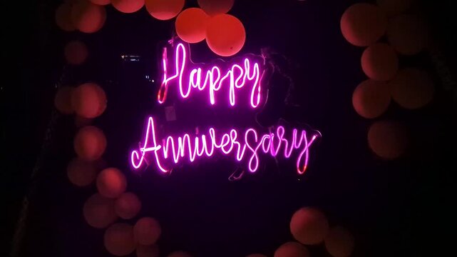 Happy Anniversary Neon Text Animation with Bokeh Lights and baloons