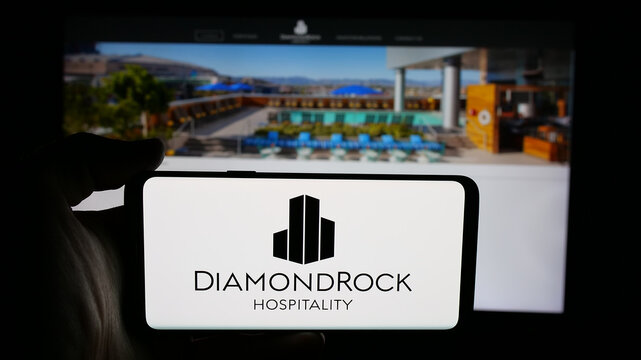 Stuttgart, Germany - 12-08-2025: Person holding cellphone with logo of REIT business DiamondRock Hospitality Company on screen in front of webpage. Focus on phone display.