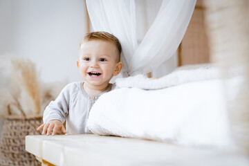 First teeth. Little caucasian small toddler son daughter kid child playing at home, growing up, learning how to walk at home. Child care and parenthood concept. Advertisement for children's products