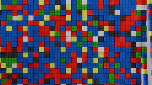 Video transition effect with fun colorful plastic toy bricks stacked on surface and then removed in a nice way. 