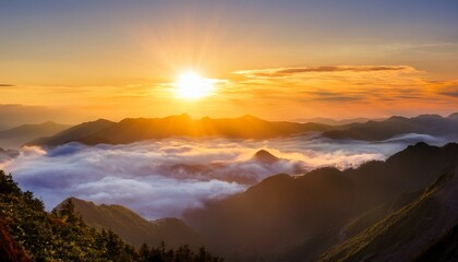 Obraz premium golden sunrise over mountain ranges shrouded in clouds
