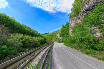 Road with a fence on the side and a mountain in the background