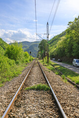 Train track with a car on the side of the road