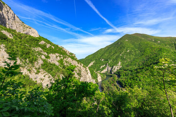 Mountain range with a river running through it and a clear blue sky