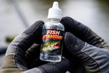 Fish Attractant: A close-up shot of a bottle of fish attractant, designed to enhance the effectiveness of fishing baits. Focus on the bottle held gently in gloved hands.