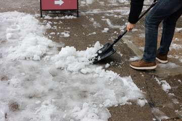 Snow removal task on a sidewalk during winter weather in an urban area