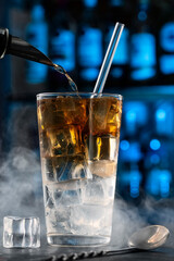 whiskey highball. Bartender Pouring Alcohol into Iced Glass &ndash; Cocktail Preparation in Bar