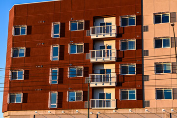 A recently built apartment building in the final stage of construction with installed windows and exterior finishes, illustrating near completion multifamily residential development