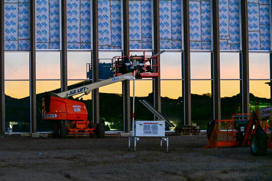 A large data center under construction with steel framing, glass panels, and a boom lift in operation, illustrating hyperscale digital infrastructure development and enterprise technology facilities