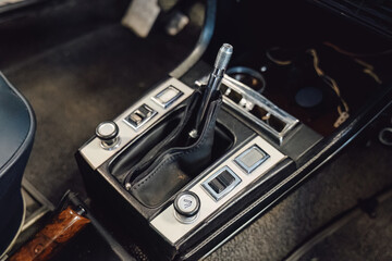 Repairing the center console trim around the gear shift lever inside a vintage car.
