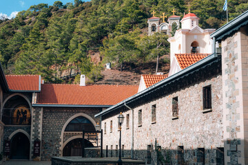 Stone orthodox monastery courtyard with church buildings and red tiled roofs, traditional religious architecture. The Holy Monastery of Panagia of Kykkos, Cyprus island