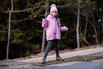 Fototapeta premium Young girl posing outdoors wearing pink winter jacket