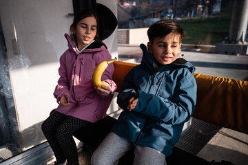 Children traveling gondola enjoying healthy banana snack © Zoran Jesic