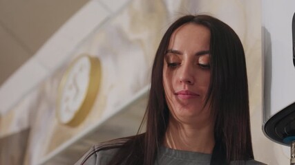 caucasian stylist checks client notes, salon professional examines consultation details attentively, caucasian stylist meticulously assesses client consultation data on tablet amidst salon decor