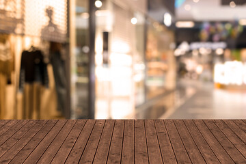 Empty wooden table against blurred view of shopping mall. Space for design