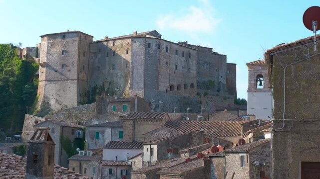 Medieval sorano fortress overlooking the village below. Scenic view of the imposing orsini fortress in sorano, a historic town built on a tuff rock in tuscany, on a sunny day