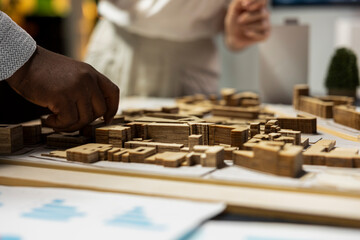 Close up of developers work together on layout city planning initiative with residential project...