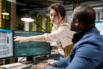 Multiethnic employees focusing on insights management on pc, planning strategies for organizational growth and aligning objectives with performance metrics for measurable productivity.