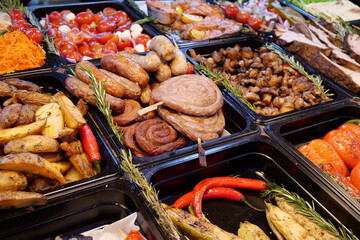 Various foods - sausages and frankfurters, fried potatoes, vegetables