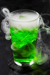 St. Patrick’s Day cocktail. Glowing Green Molecular Cocktail with Smoke on Dark Background. Halloween