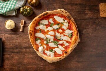 Neapolitan margherita pizza with basil on wooden table