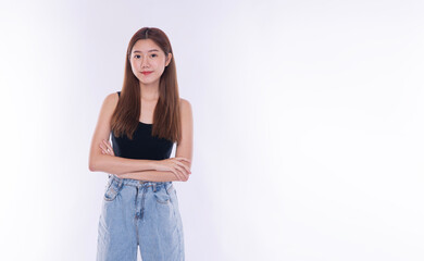 Confident young Asian woman standing with arms crossed looking at camera on white background. Smart casual female portrait with smile and copy space for text.