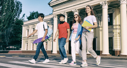 Fototapeta premium Students in campus. Teenage girls and boys crossing street together