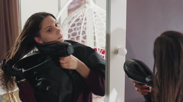 caucasian lady blowdrying hair, woman beautician using tools to shape her hairstyle precisely, caucasian woman meticulously blowdrying and texturizing her hair in front of reflective surface