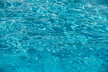 Ripped water in swimming pool. Surface of blue swimming pool, background of water.