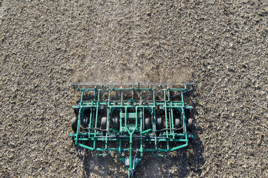 Aerial view of tractor plowing soil. Tractor plowing farmland. Agricultural work. Tractor cultivating soil. Farming machinery. Tractor plowing land. Farm machinery working. Plowing from top. - Powered by Adobe