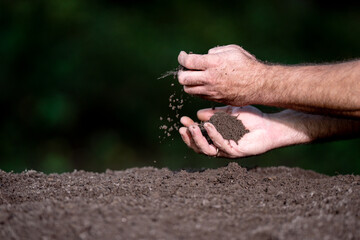 Hands holding soil. Farmers hands full of soil. Pouring soil and testing soil. Gardener examining earth and compost fertility.