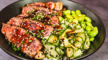Beautiful oriental bowl with thin slices of rare sirloin, edamame, sunomono salad, and teriyaki sauce. Vibrant colors, fresh ingredients, perfect for a healthy and gourmet meal.