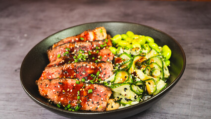 Beautiful oriental bowl with thin slices of rare sirloin, edamame, sunomono salad, and teriyaki sauce. Vibrant colors, fresh ingredients, perfect for a healthy and gourmet meal.