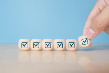 Hand holding wooden block with tick mark, good feedback rating and positive customer review, experience, satisfaction survey ,mental health assessment, checklist business concept