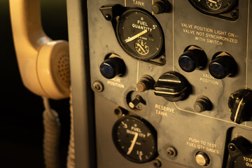 Close-up of a vintage military communication panel with dials, gauges, and a telephone receiver.