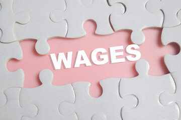 Fototapeta premium Piece of jigsaw puzzle with word wages. Business and finance concept