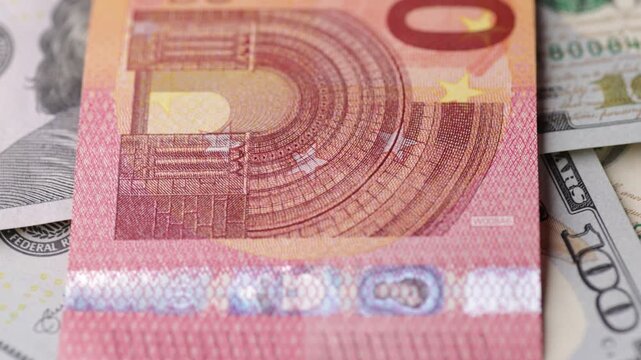 Mixed euro and dollar banknotes rotating in macro closeup showing color contrast seamless loop