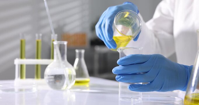 Scientist checking motor oil quality at table in laboratory, closeup