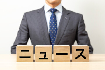 「ニュース」と書かれたブロックとビジネスマン