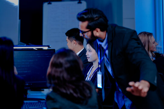 Data-driven deep dive: Analysts side-by-side, immersed in complex datasets across multiple screens. Monitoring real-time analytics or training machine learning models late night.